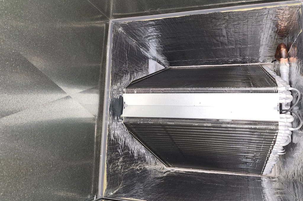 : A close-up of a pristine metal duct and coil, demonstrating the effectiveness of professional duct cleaning services.